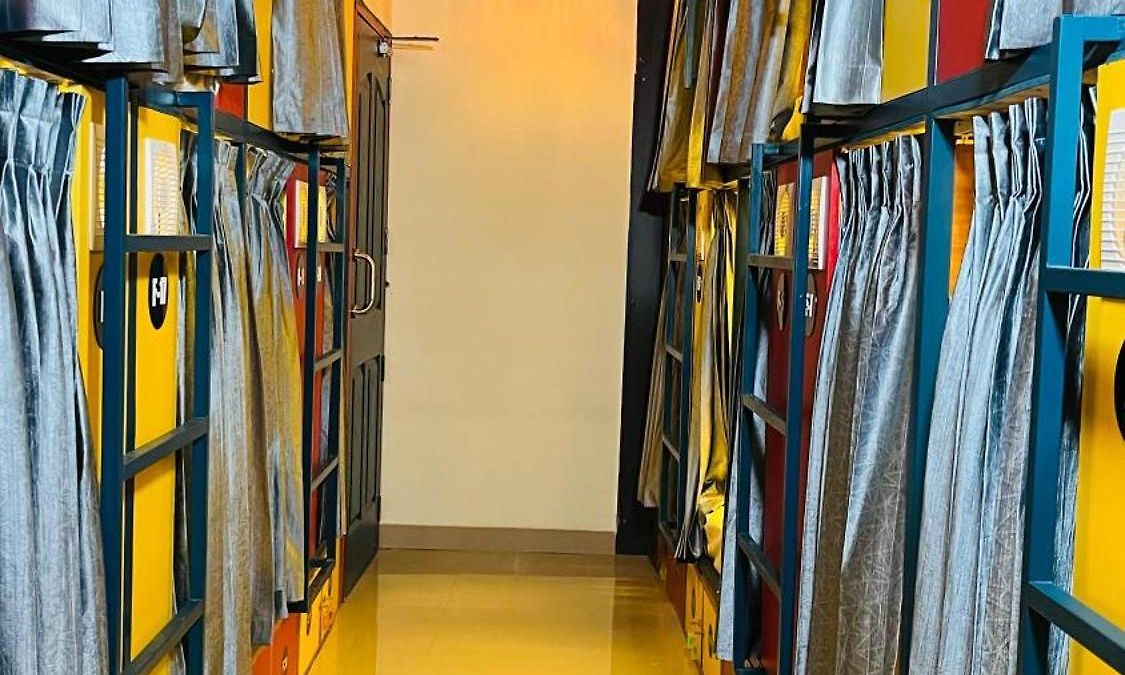 Dorm corridor of capsule pods with privacy curtains